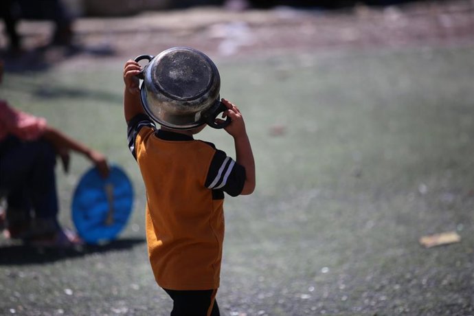 Un niño palestino espera para recibir raciones limitadas de comida en medio de la escasez de alimentos por la ofensiva israelí en el campo de refugiados palestinos de Nuseirat, en el centro de la Franja de Gaza