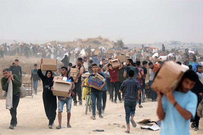 Archivo - June 8, 2025, Bureij, Gaza Strip, Palestinian Territory: Palestinians walk with aid supplies which they received from the U.S.-backed Gaza Humanitarian Foundation, in Al-Bureij, central Gaza strip, on June 8, 2025
