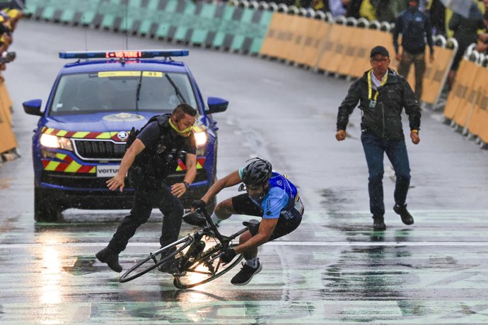 23 July 2025, France, Valence: A French Republican Security Corps officer (L) and a Tour de France staff member intercept an individual attempting to cycle across the finish line before the final sprint of the Tour de France cycling race, 160,4 Km from Bo
