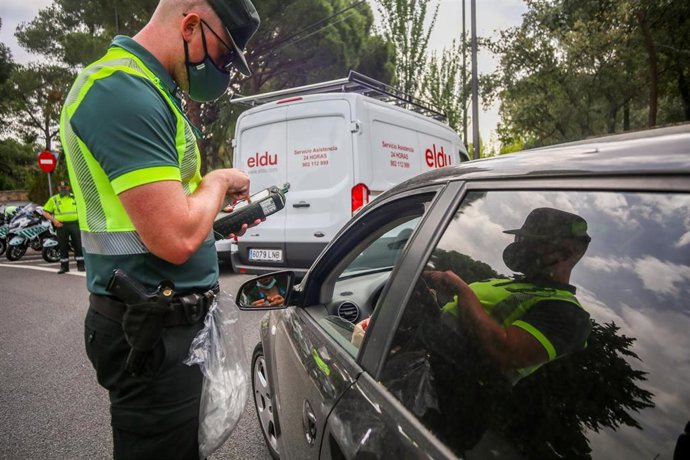 Archivo - Un agente para a los coches para someter a pruebas de control de consumo de drogas y alcohol a los conductores durante la presentación de una nueva campaña de la DGT. 