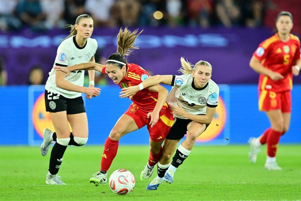 23 July 2025, Switzerland, Zurich: Spain's Aitana Bonmati (C) battles for the ball with Germany's Elisa Senss (R) and Jule Brand during the UEFA Women's Euro 2025 semi-final soccer match between Germany and Spain at Letzigrund Stadium.