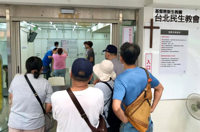 26 July 2025, Taiwan, Taipeh: Taiwanese voters watch the counting of votes at a polling station in a small church in the Songshan district of Taipei. 24 members of parliament from the opposition Nationalist Party are facing a recall election in Taiwan. Th