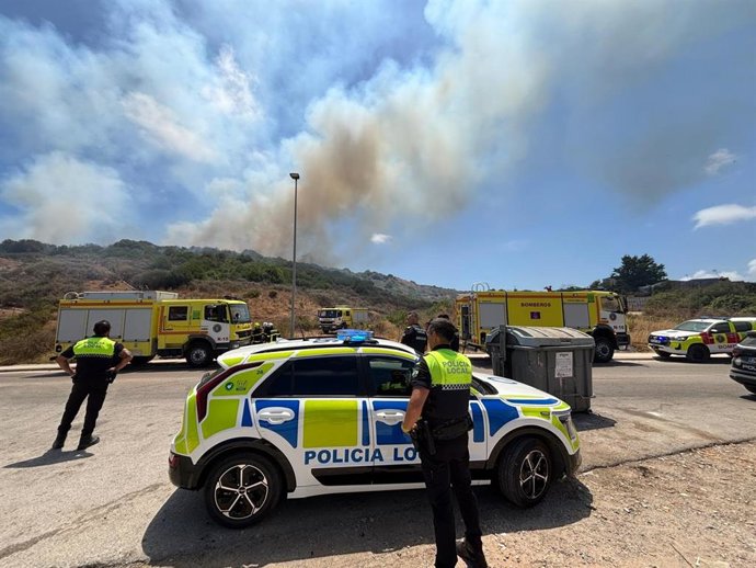 Bombeiros e polícia local na área do incêndio em Agua Marina, em Algeciras.