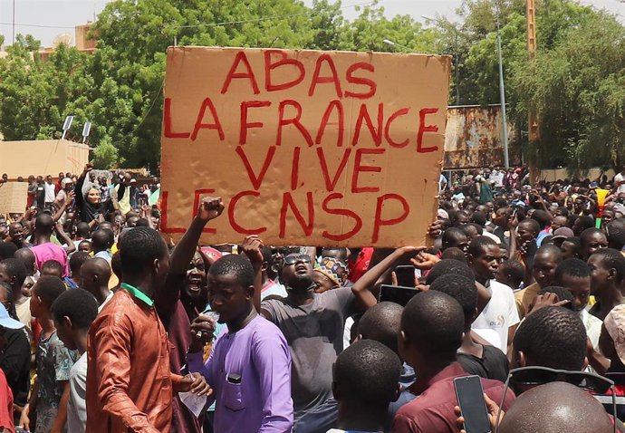 Archivo - Manifestantes con un cartel que dice "Abajo Francia, viva el Consejo Nacional para la Salvaguarda de la Patria (CNSP)" durante una marcha en apoyo a los golpistas en la capital de Níger, Niamey