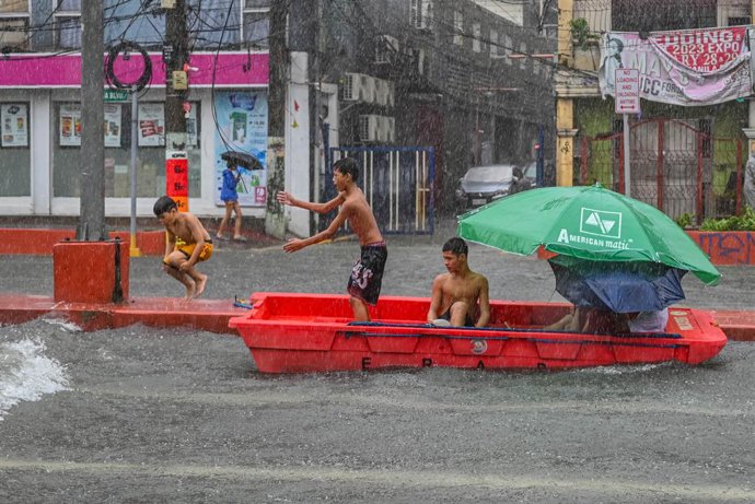 July 22, 2025, Quezon City, Quezon, Philippines: Children play with an abandoned rescue boat in Manila.