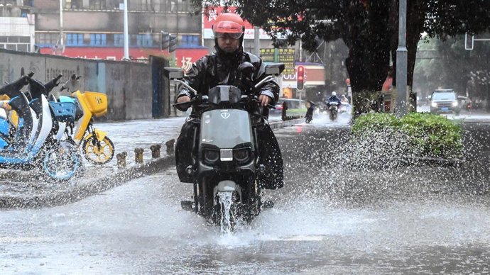 QINZHOU, 21 de julho de 2025 -- Um homem dirige uma motocicleta sob a chuva em Qinzhou, Região Autônoma de Guangxi Zhuang, no sul da China, em 21 de julho de 2025.   O tufão Wipha provocou fortes chuvas em Guangxi na segunda-feira.