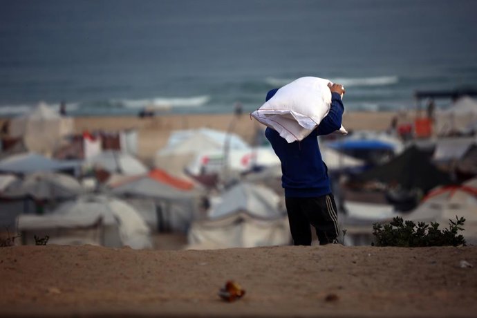 Archivo - June 10, 2025, Gaza City, Gaza Strip, Palestinian Territory: People carry their sacks of flour Flour they got from aid trucks in Gaza City, where there is a food crisis due to Israeli attacks, on June 10, 2025. Palestinians living under difficul