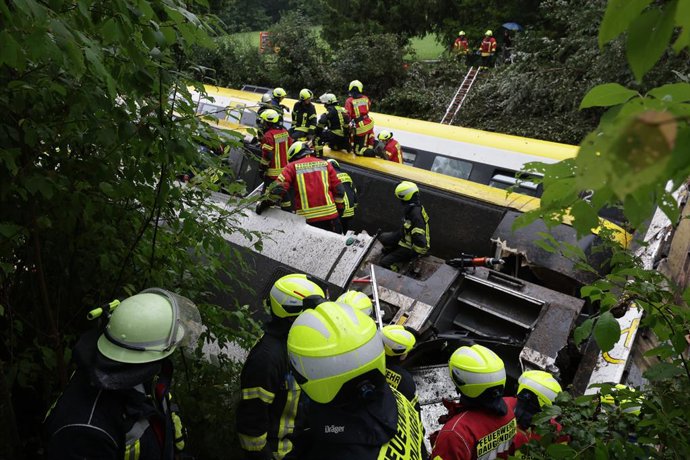 27 July 2025, Riedlingen: Rescue workers search for passengers in a derailed train.  Several people have been killed and many others injured after a passenger train derailed in Biberach district between Zweifaltendorf and Zell in south-western Germany. Ph