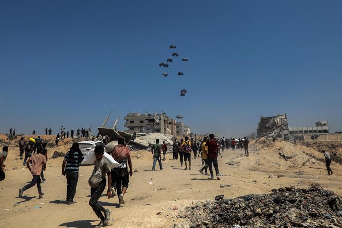 GAZA, July 28, 2025  -- People wait for the humanitarian aid dropped by an airplane in Gaza City, July 27, 2025. The Israeli military on Sunday announced a daily 10-hour humanitarian pause in its operations in parts of the Gaza Strip, along with the openi