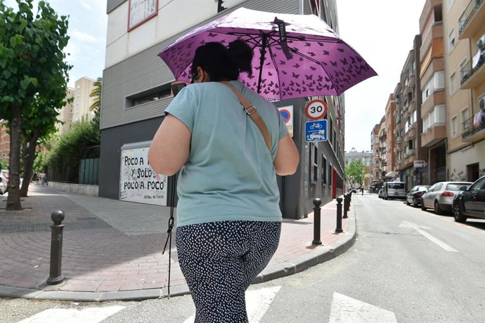 Archivo - Una mujer pasea por la calle con un paraguas para protegerse del sol, a 27 de abril de 2023, en Murcia, Región de Murcia (España). Las lluvias han dejado en la Región de Murcia ocho veces menos cantidad que hace un año. La Aemet ha registrado, d