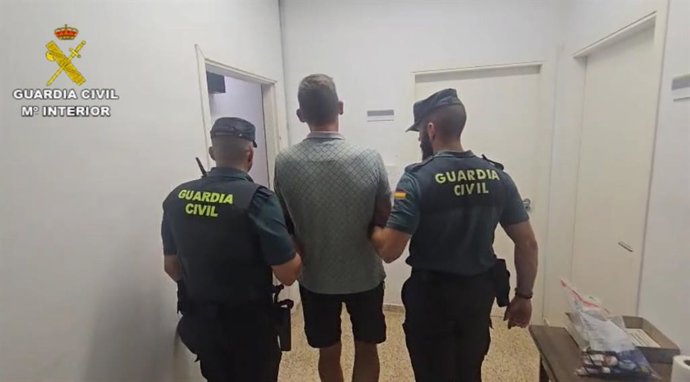 El detenido, de espaldas, junto a dos agentes de la Guardia Civil.