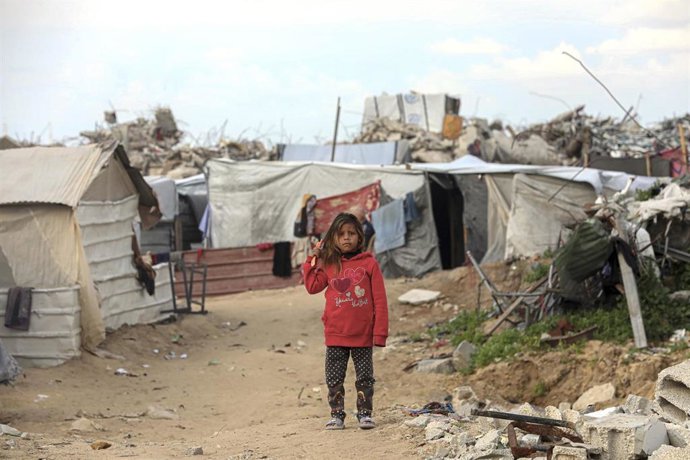 Archivo - Una niña junto a una tienda de campaña en la Franja de Gaza
