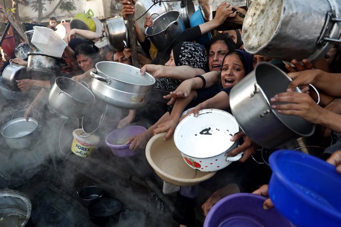 BEIJING, July 22, 2025  -- Palestinians wait to receive food in the Al-Rimal neighborhood of central Gaza City, on July 20, 2025. The total death toll of hunger in Gaza since March has reached 86, including 76 children, the Gaza-based health authorities s