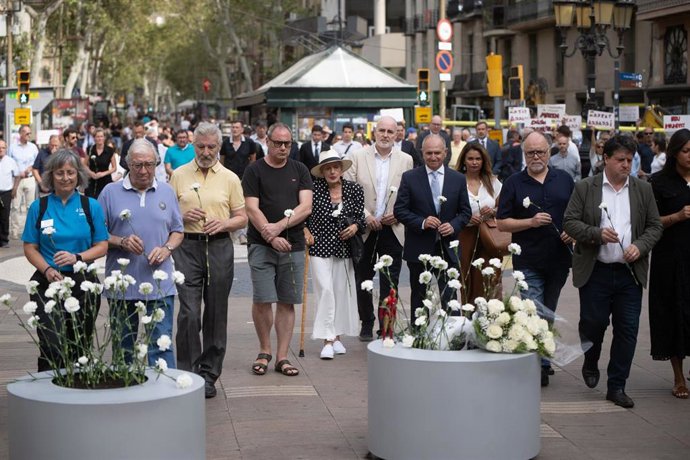 Archivo - Varias personas participan en una ofrenda floral en un homenaje a las víctimas del atentado del 17-A en una imagen de archivo.