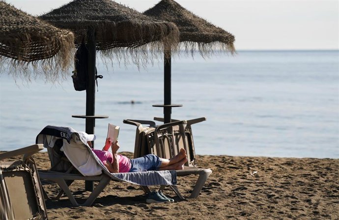 Archivo - Imagen de archivo de personas tomando el sol en la playa de la Malagueta, en Málaga, en diciembre.