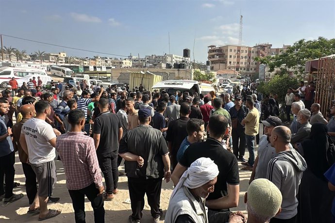 Archivo - Imagen de archivo de un grupo de palestinos junto a una ambulancia en Jan Yunis.