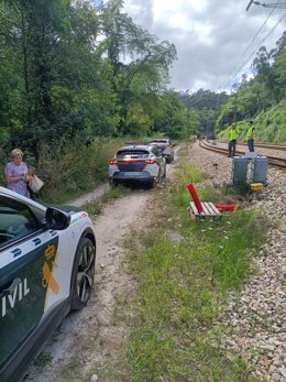 Coches de la Guardia Civil trasladan a pasajeros de un tren de cercanías que sufrió una incidencia en la línea Gijón-El Berrón.