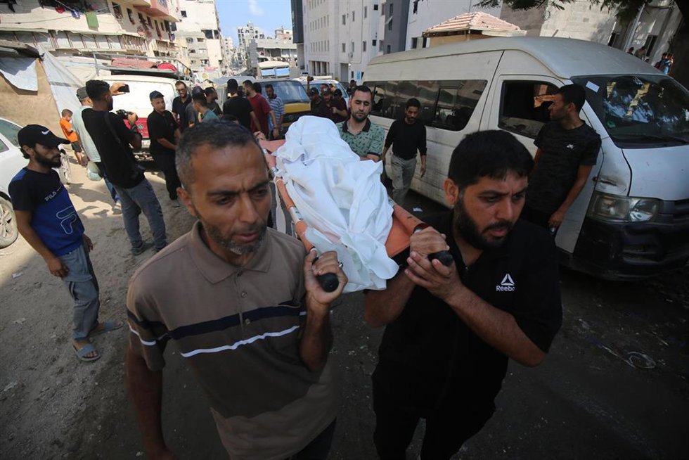 Un grupo de palestinos porta el cadáver de unos de sus familiares muerto por los ataques de Israel.