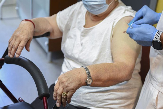 Archivo - Arxiu - Una dona rep una dosi de la vacuna contra la grip