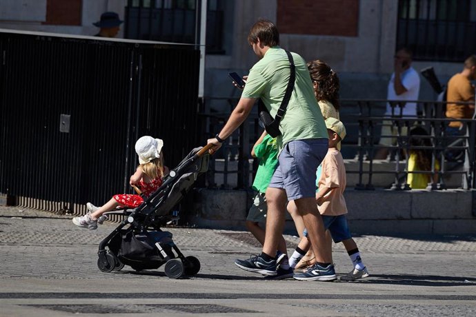 Un hombre pasea con sus hijos.