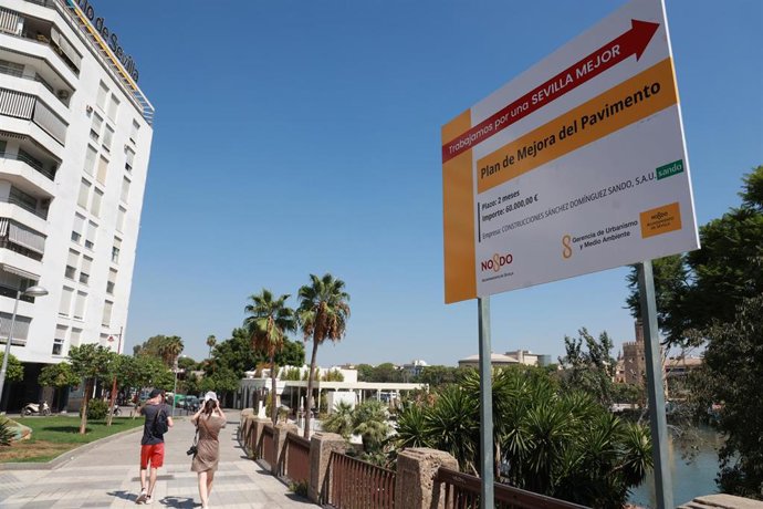 Archivo - Cartel de las obras de pavimentación, junto al río Guadalquivir, en una imagen de recurso.