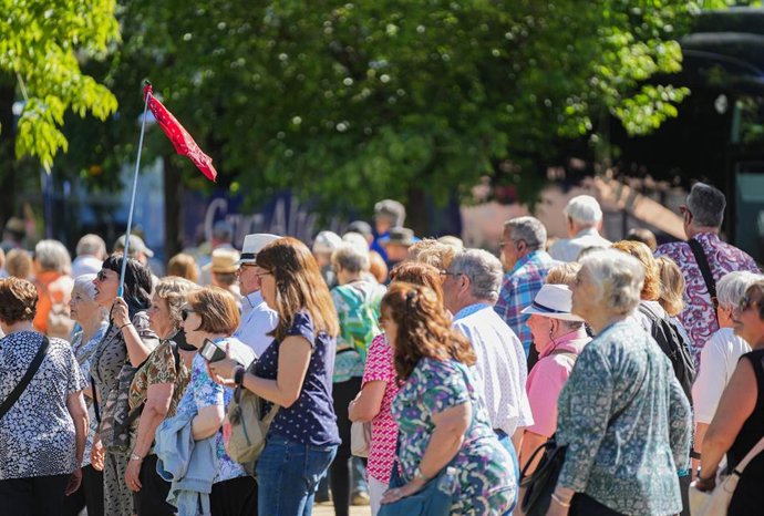 Archivo - Imagen de archivo de un grupo de turistas siguiendo a un guía por el casco histórico de Sevilla.