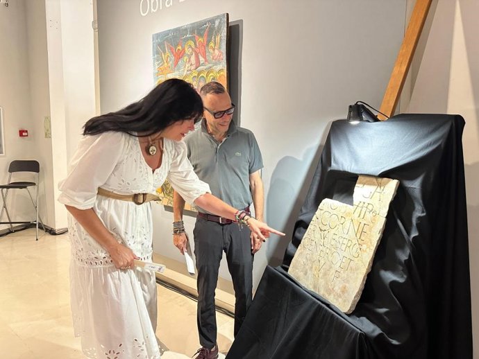 La alcaldesa de Huesca, Lorena Orduna, y el direcror general de Cultura, Pedro Olloqui, ante la lápida romana.