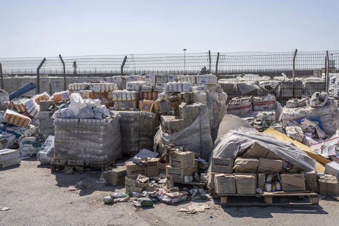 24 de julho de 2025, Territórios Palestinos, Kerem Shalom: Pilhas de pacotes de ajuda humanitária esperam para serem retirados no lado palestino da passagem de Kerem Shalom, na Faixa de Gaza, durante uma visita da mídia organizada pelo exército israelense