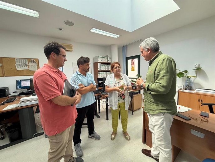 El delegado territorial de Salud, Juan de la Cruz Belmonte, durante su visita a uno de los centros del Distrito Sanitario Poniente para supervisar la aplicación del Plan Verano junto a profesionales sanitarios.
