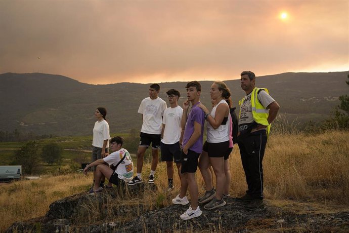 Varias personas observan las labores de extinción, a 30 de julio de 2025, en A Cañiza.