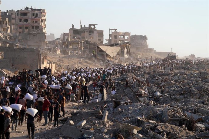 Palestinos con paquetes de ayuda humanitaria en la Franja de Gaza