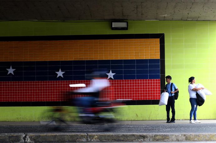 Archivo - Vista de la bandera venezolana sobre las calles de la localidad venezolana de Valencia