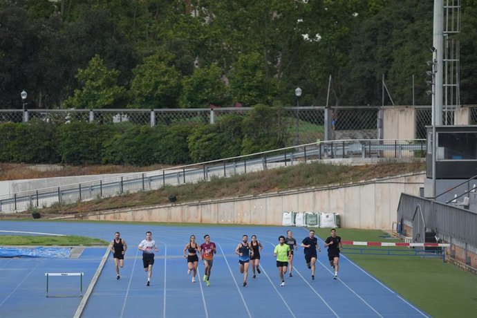 Atletas entrenando en una pista de atletismo