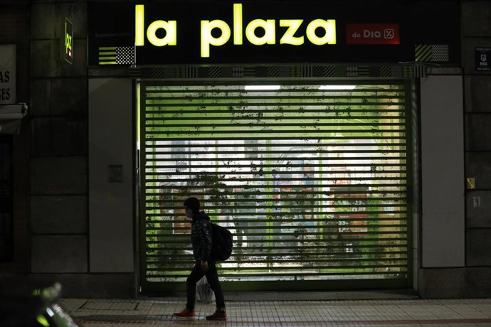 Archivo - Un hombre pasa delante de un supermercado Día cerrrado en Salamanca.