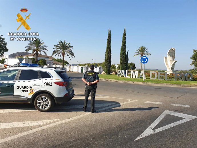Archivo - Una agente y un vehículo de la Guardia Civil en Palma del Río.