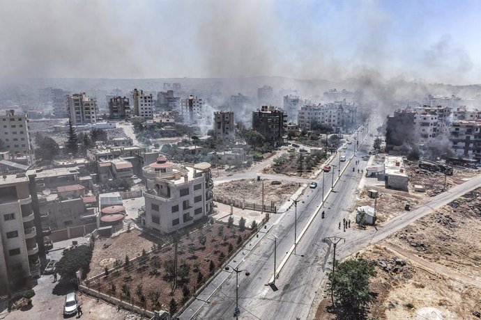 19 July 2025, Syria, As Suwayda: An aerial view shows the city of As Suwayda, with smoke rising from burning houses amid clashes between tribal fighters and local Druze factions in southern Syria. Fear and shock grip the province following the escalation 