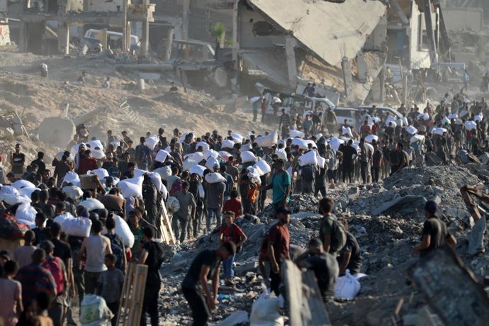 July 30, 2025, Gaza City, Gaza Strip, Palestinian Territory: Palestinians, driven to the brink of starvation under Israeli army's attacks and blockade, gather at an aid distribution point in Gaza Zikim Corridor to access a limited supply of flour in Gaza 