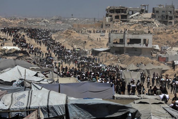 BEIT LAHIA, 2 de agosto de 2025 -- Palestinos carregam ajuda humanitária em Beit Lahia, no norte da Faixa de Gaza, em 1º de agosto de 2025.