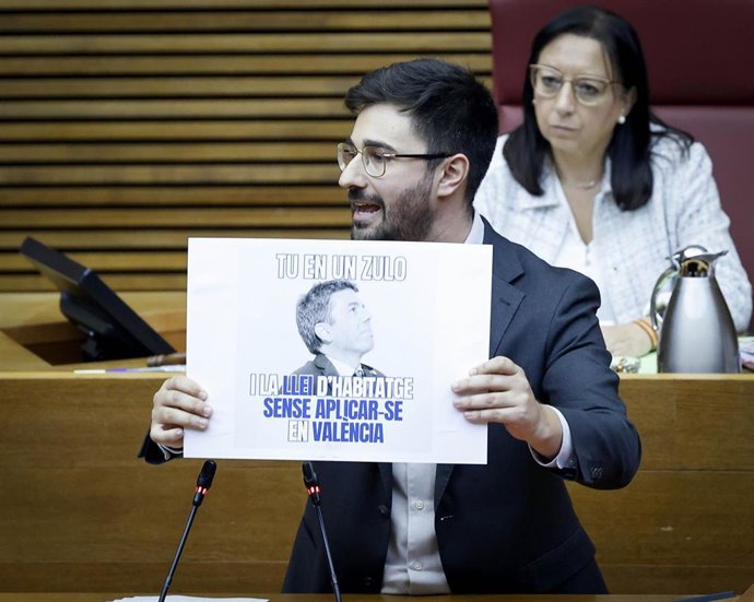 Archivo - El diputado del PSPV Benjamín Mompó muestra un cartel en el pleno de Les Corts. Imagen de archivo