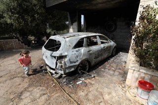RAMALLAH, Aug. 1, 2025  -- A Palestinian girl runs past a burnt car following an Israeli settler attack in the village of Silwad, in the West Bank city of Ramallah, on July 31, 2025.