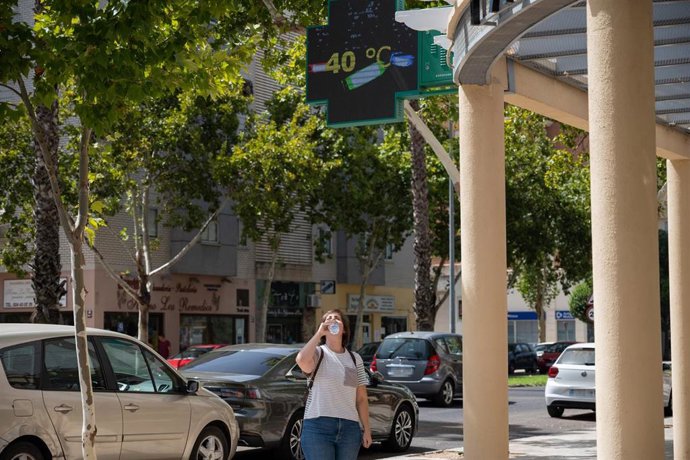 Archivo - Una mujer bebe agua en un día de calor en Badajoz. Imagen de archivo