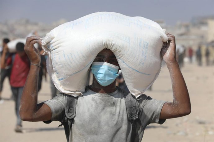 Um palestino com um pacote de farinha entregue por um caminhão de ajuda humanitária no norte da Faixa de Gaza.