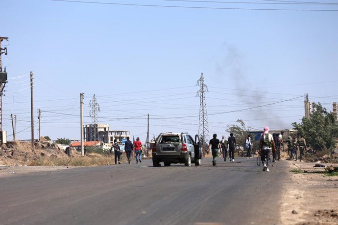 SWEIDA, July 18, 2025  -- Tribal fighters gather on a road near a frontline in the town of Wolgha, western countryside of Sweida, southern Syria, on July 18, 2025. The Syrian interim authorities on Friday issued a call for restraint amid escalating violen