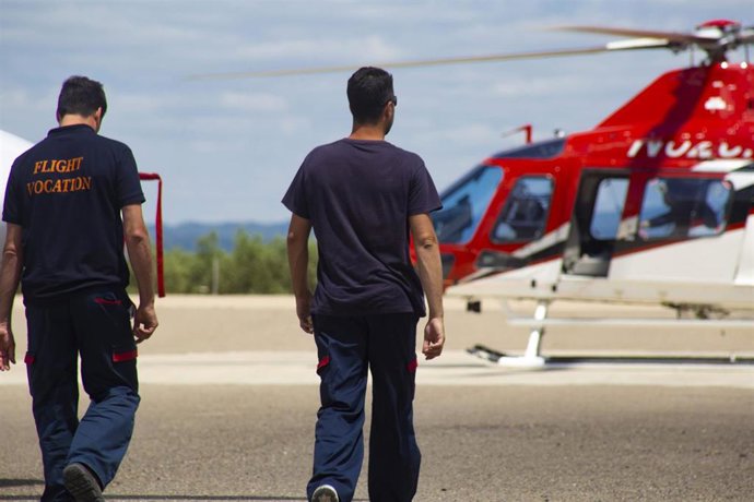 Archivo - Dos hombres caminan hacia un helicóptero.