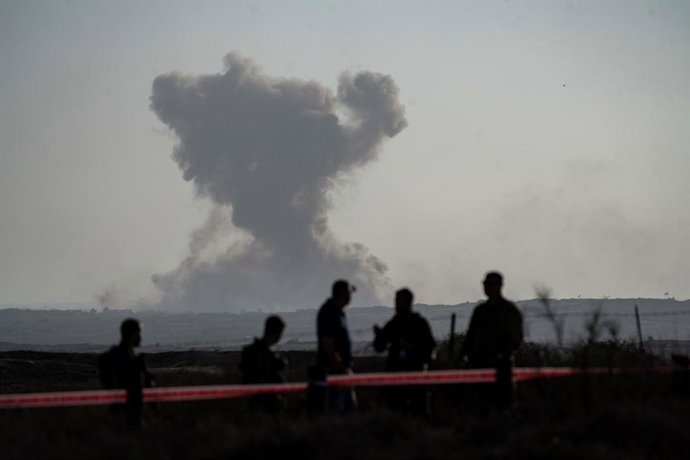30 July 2025, Israel, ---: Israeli right-wing settlers look at smoke rising from the Gaza Strip, seen from southern Israel. Photo: Ilia Yefimovich/dpa