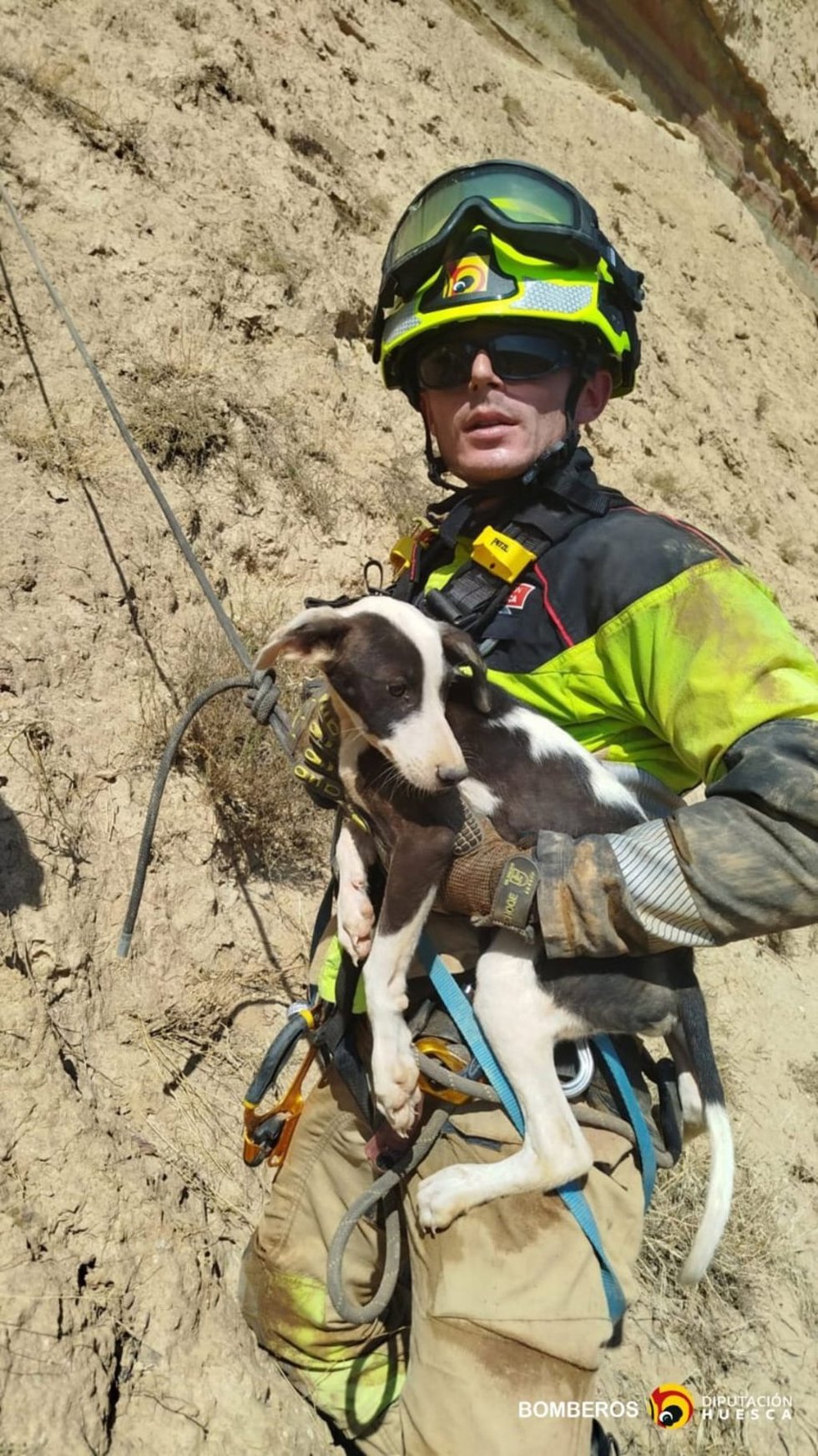 Un de los bomberos con el perro rescatado.