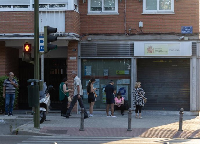 Varias personas hacen cola en una oficina del SEPE.
