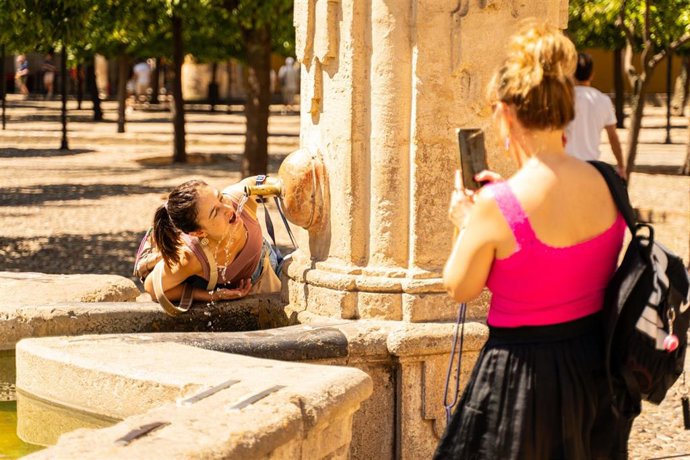Archivo - Turistas se refrescan con agua para hacer frente a las altas temperaturas registradas en la capital cordobesa, a 19 de agosto de 2024 en Córdoba (Andalucía, España).  