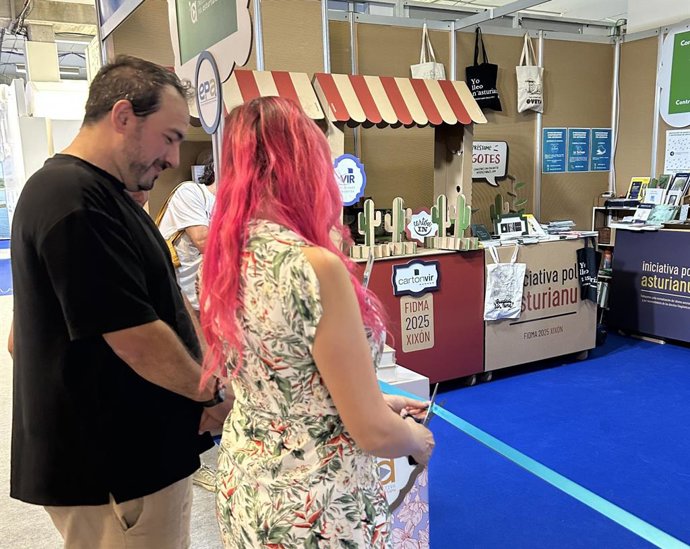 La presidenta d’Iniciativa pol Asturianu cortando la cinta inaugural del espaciu del idioma na Feria de Muestres.