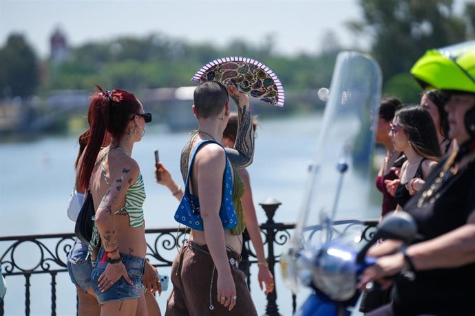 Archivo - Turistas pasean por el Puente de Triana en Sevilla. Imagen de archivo.
